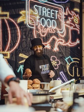 Un personne qui porte un tablier Lyon street food, sert du pain. Cette image montre que c'est tendance d'avoir des textiles personnalisé pour 2025.
Tendances personnalisation textile 2025